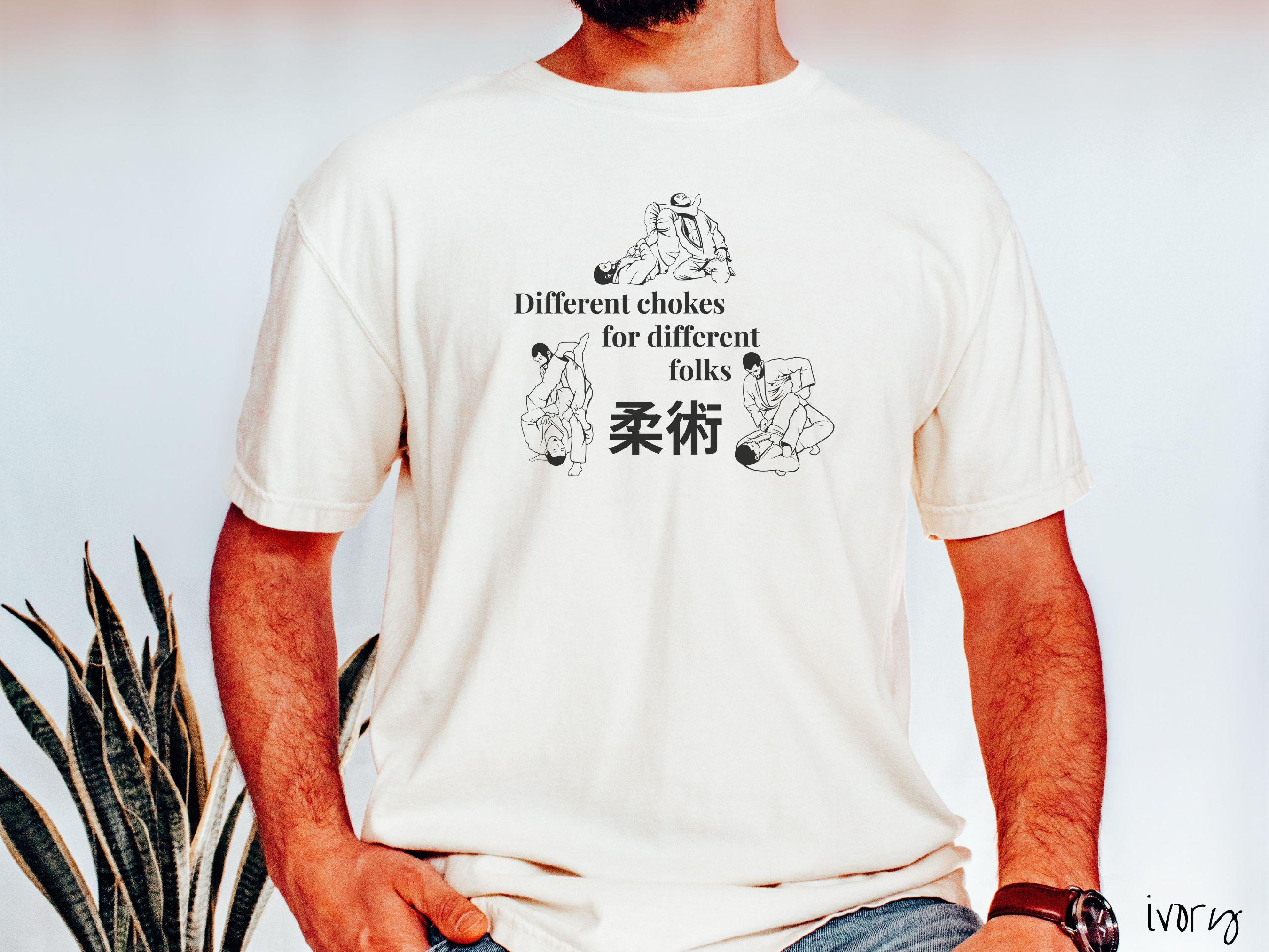 A t-shirt featuring three line art illustrations of Jiu-Jitsu grappling moves. The text reads 'Different chokes for different folks' with Japanese Kanji for 'Jiu-Jitsu' in the center."