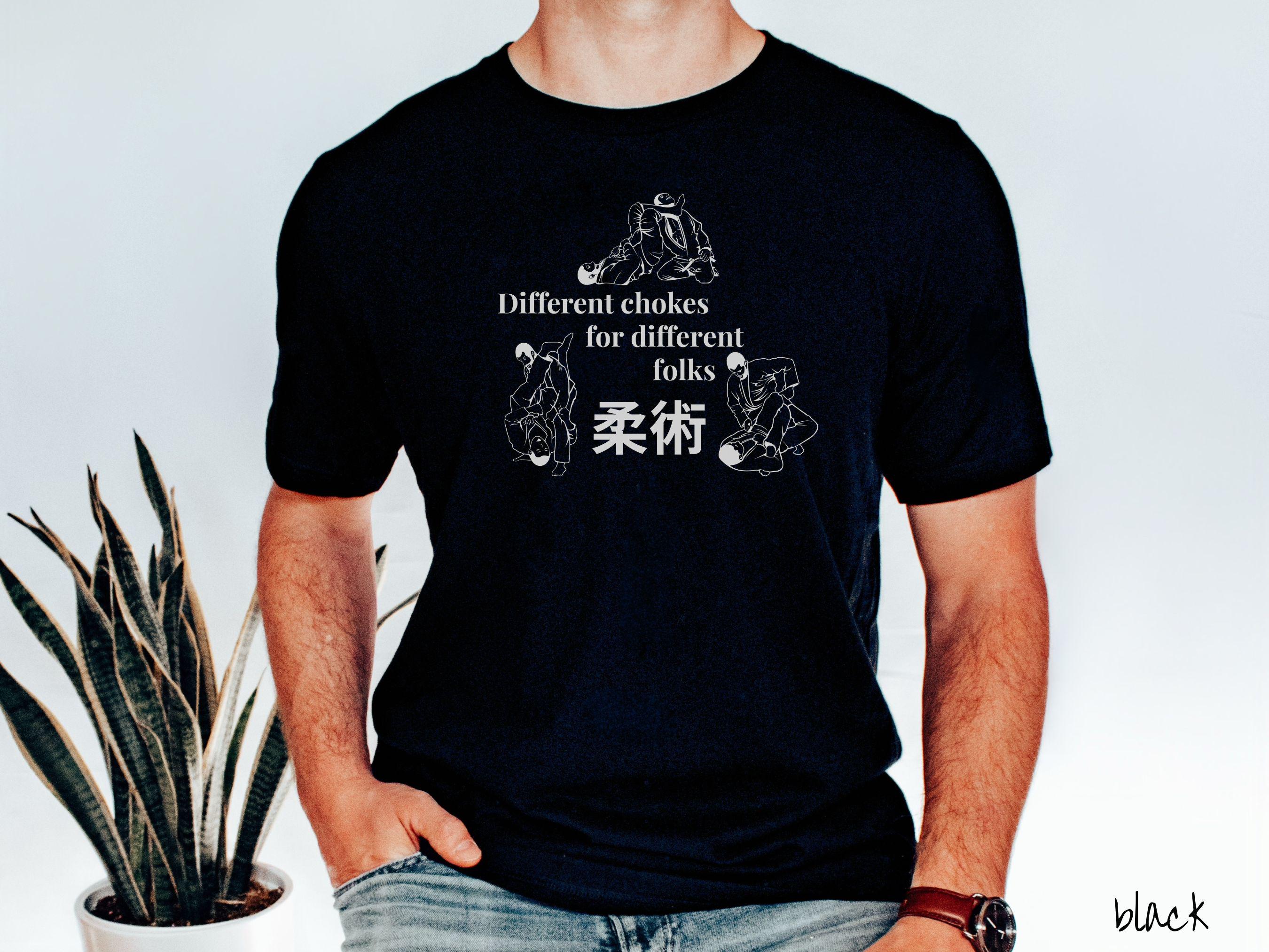 A t-shirt featuring three line art illustrations of Jiu-Jitsu grappling moves. The text reads 'Different chokes for different folks' with Japanese Kanji for 'Jiu-Jitsu' in the center."